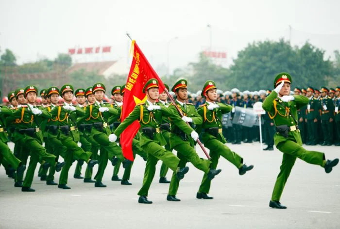 Công an diễu hành với cờ đỏ trong nghi lễ trang trọng