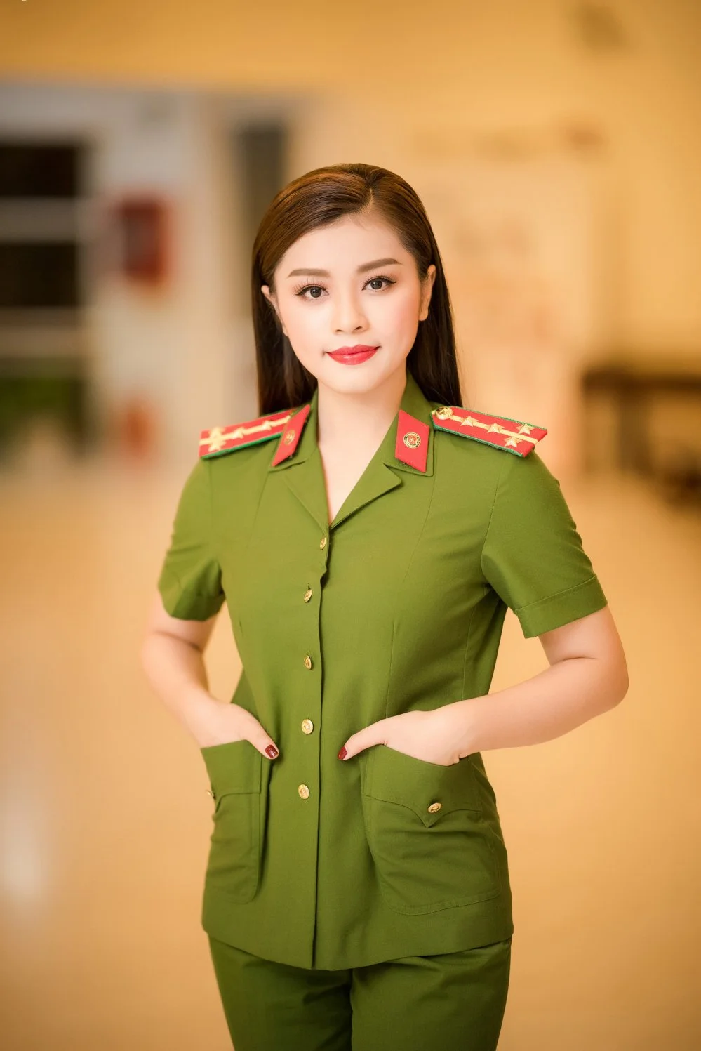 Nữ công an mặc đồng phục xanh tạo dáng trong khung cảnh trang trọng