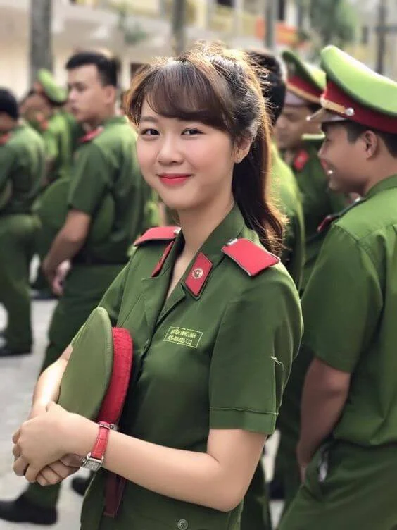 Nữ công an trẻ mỉm cười trong bộ đồng phục giữa các đồng đội