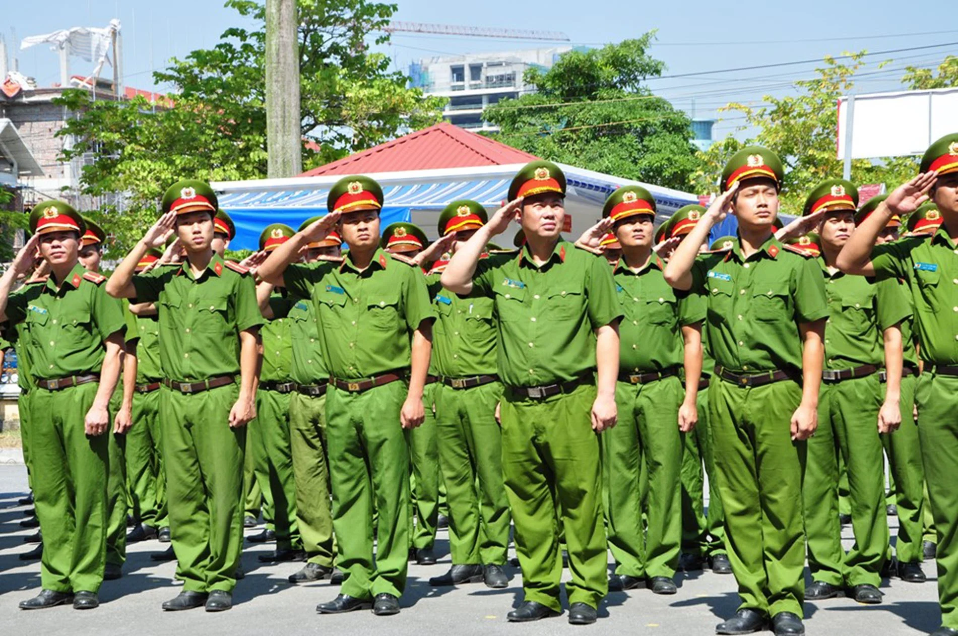 Đội hình công an mặc đồng phục xanh diễu hành ngoài trời