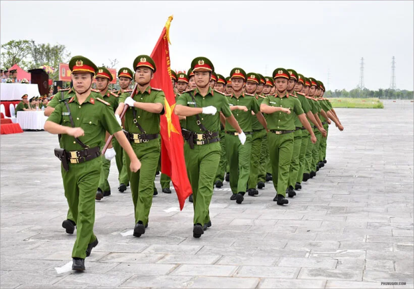 Đội hình công an cầm cờ diễu hành trên quảng trường
