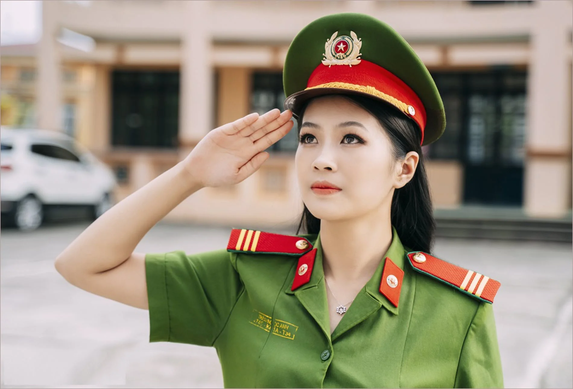 Ảnh công an nữ Việt Nam mặc quân phục màu xanh, đội mũ kepi và thực hiện động tác chào nghiêm trang