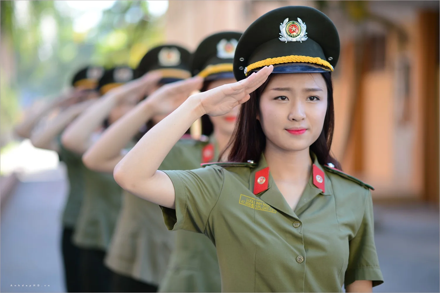 Ảnh công an nữ Việt Nam mặc quân phục và đội mũ kêpi đang nghiêm trang chào theo đội hình