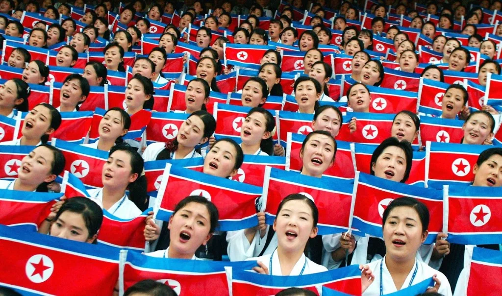 Đám đông người dân cầm cờ Triều Tiên trong một sự kiện tập thể