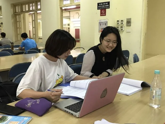 Hai nữ sinh đang học tập cùng nhau với máy tính xách tay