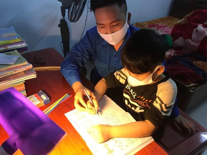 Người lớn hướng dẫn trẻ em học tập tại nhà